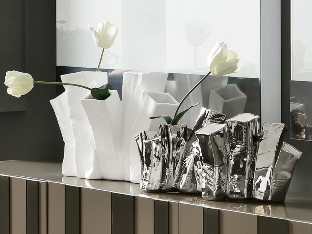 Κοντινό πλάνο σε διακοσμητικά βάζα με οργανικές φόρμες και μεταλλικές υφές.