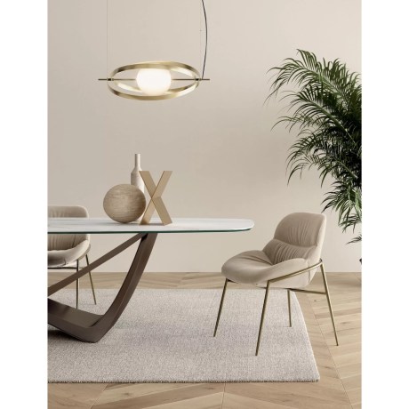 Kαρέκλα Amelie 34.90 Conical Tube Frame με μπεζ βελούδινη επένδυση εμφανίζεται σε λήψη τραπεζαρίας, τονίζοντας το cozy κάθισμα και τη σταθερή μεταλλική βάση της.