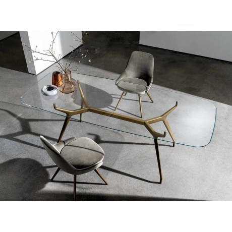 Arkos Oval Shaped 02 τραπέζι με διαφανή γυάλινη επιφάνεια και χρυσή βάση.