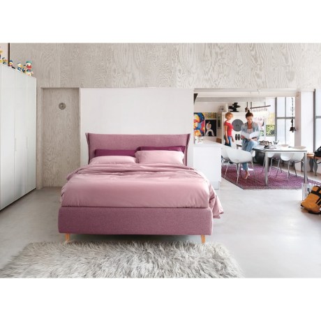 Κρεβάτι με ύφασμα και ξύλινα πόδια σε χώρο loft